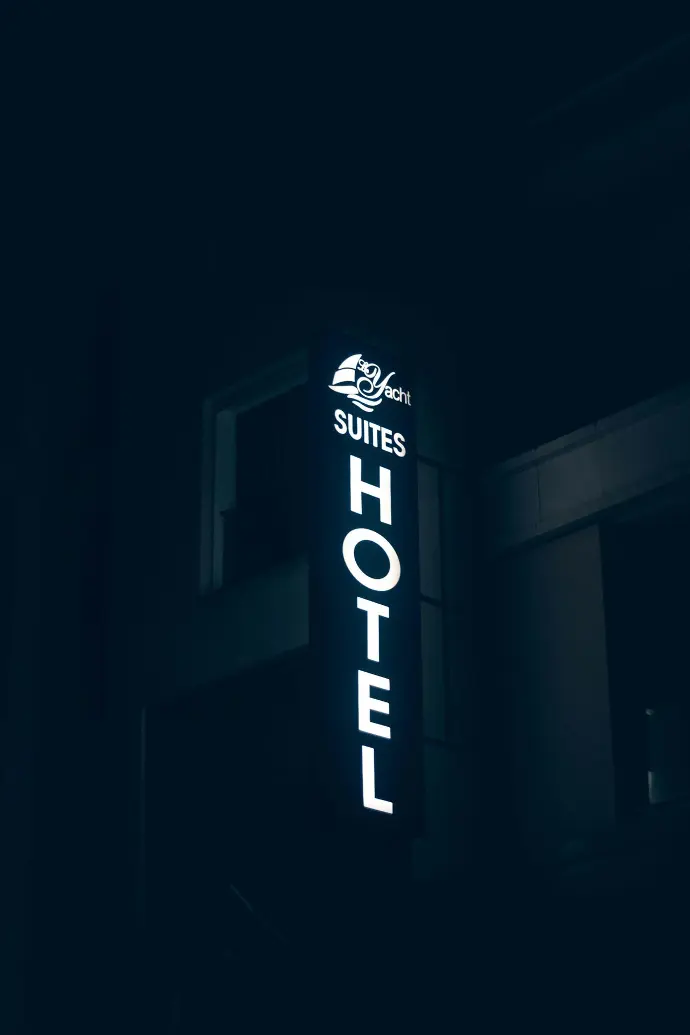 a hotel sign lit up in the dark